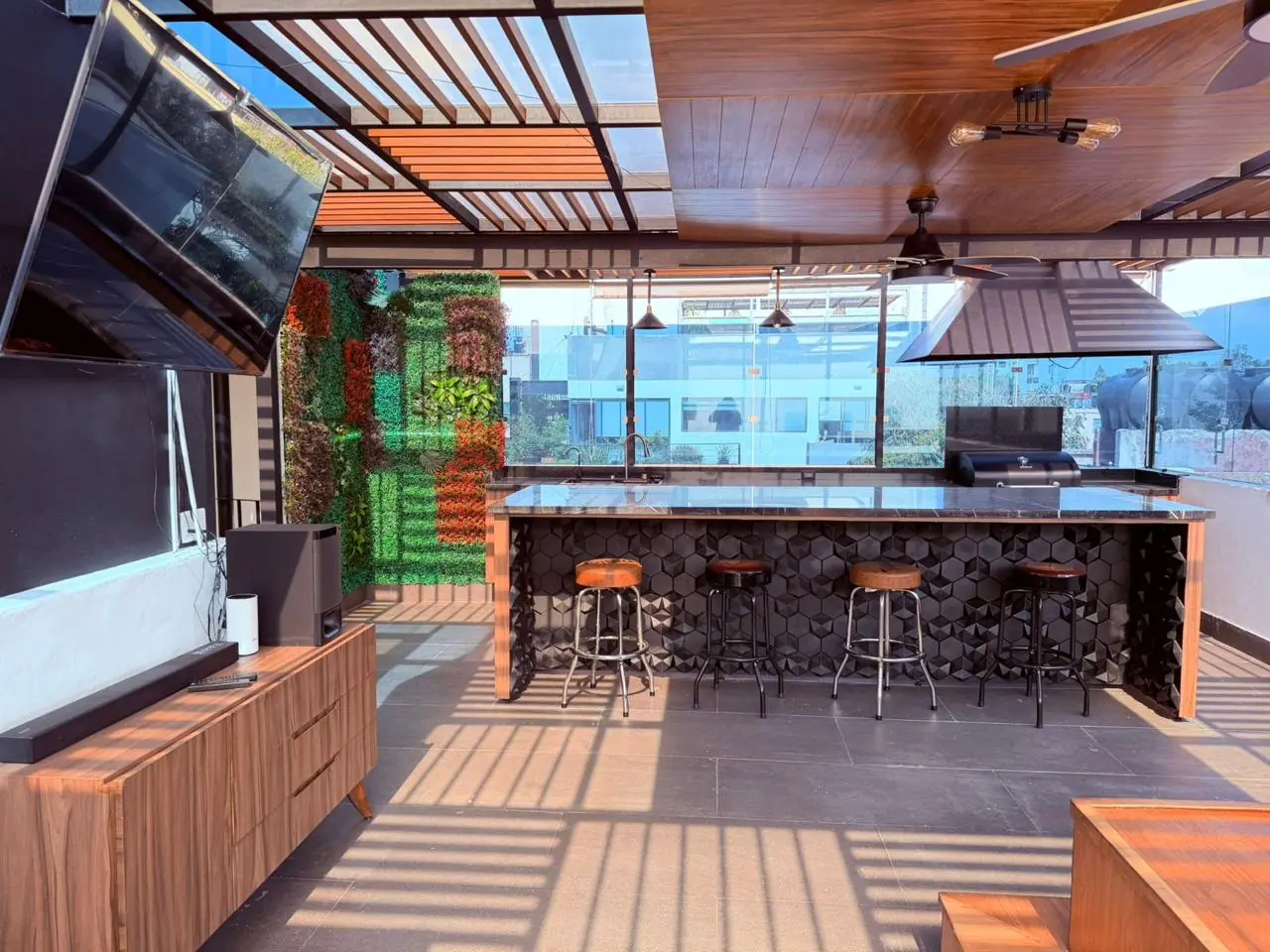 Roof garden privado con barra y espacio audiovisual del penthouse