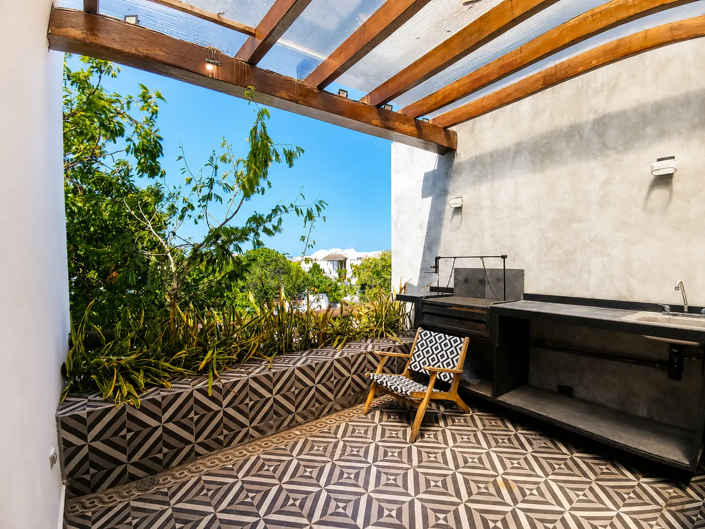 Terraza privada con pérgola y estación de asador