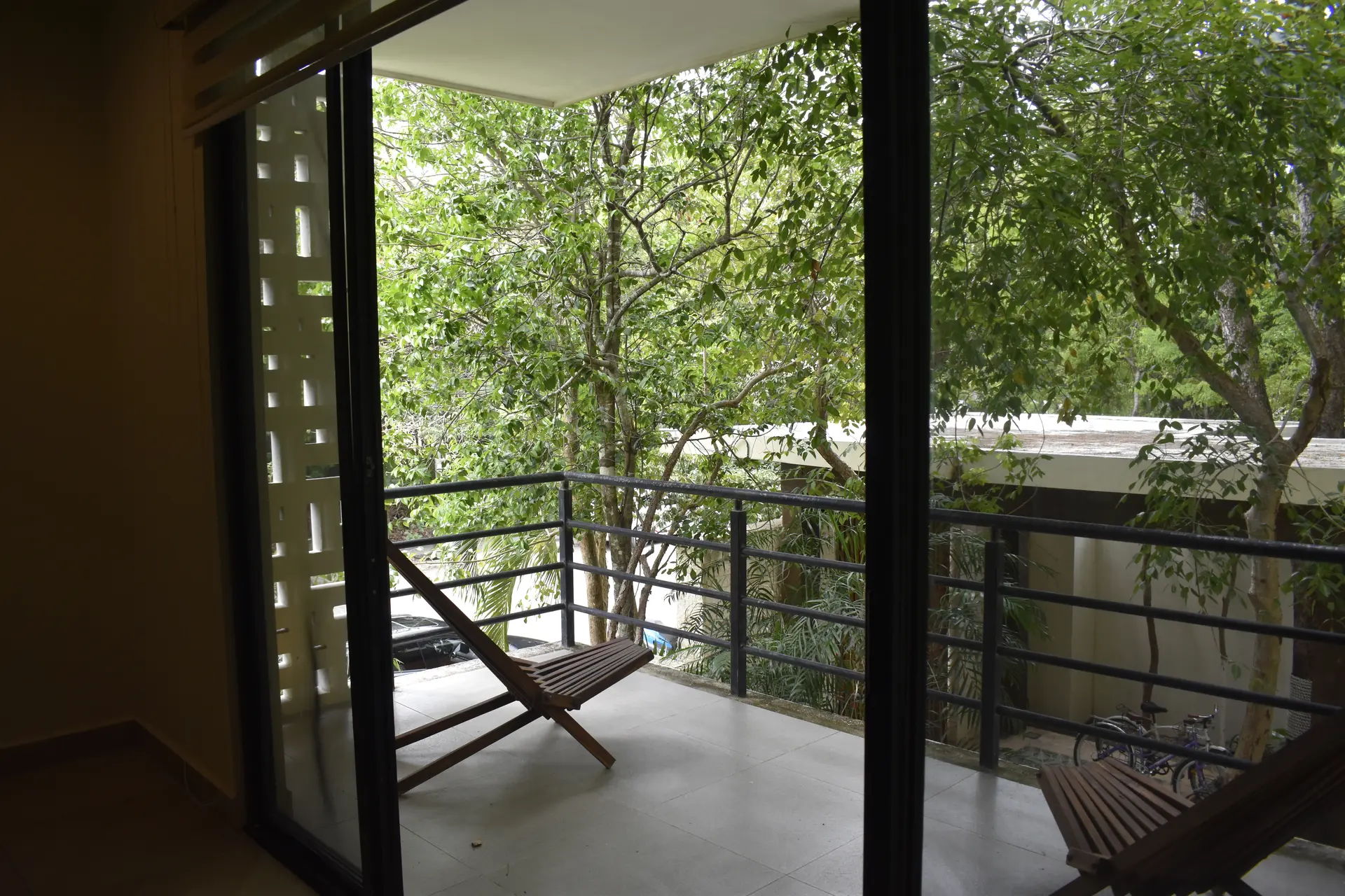 Balcón del departamento con vista entre árboles
